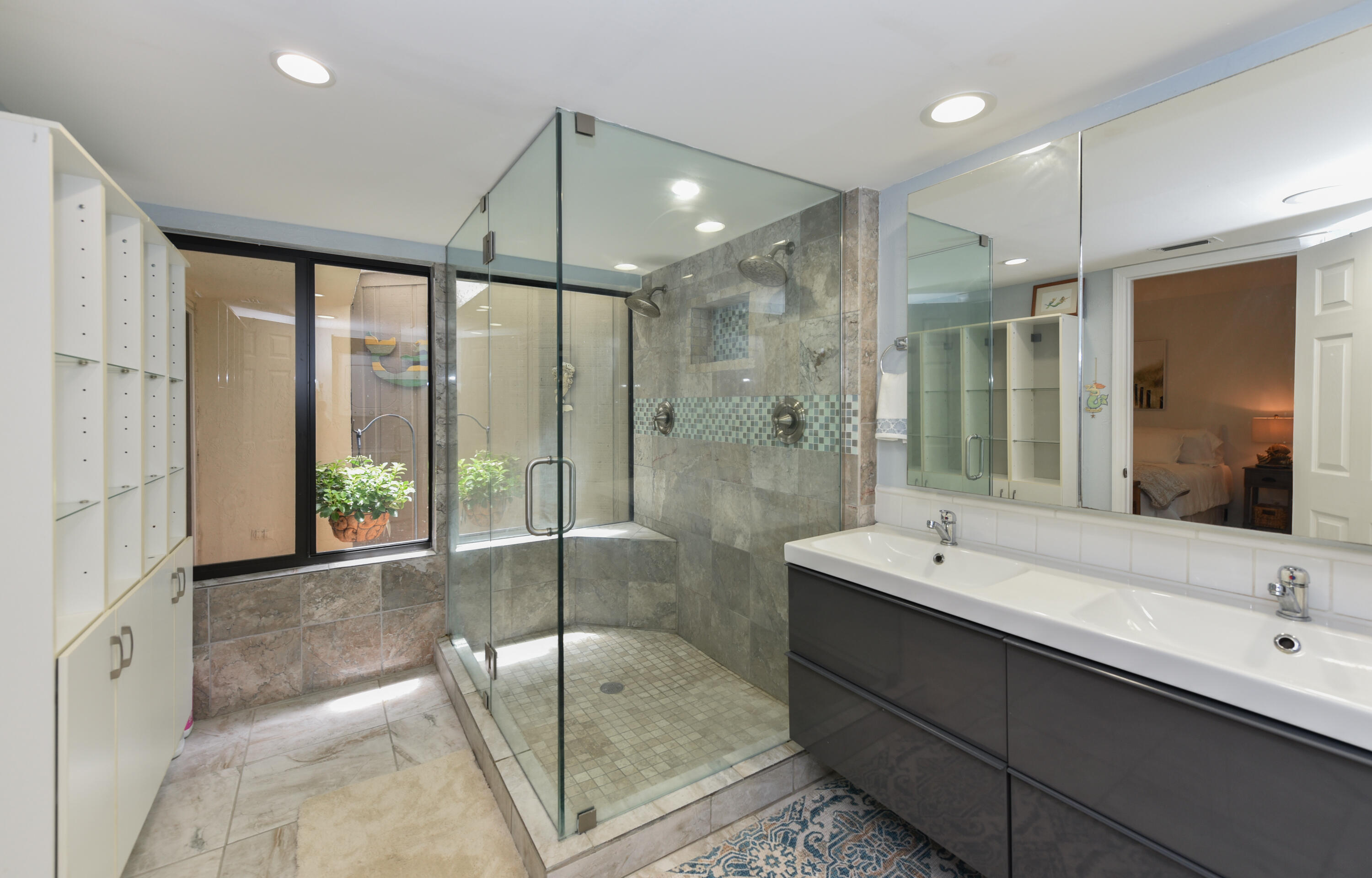 1605 Highway 1, Unit 1D Jupiter, FL 33477 - Photo 24 of 54 a bathroom with a double vanity sink and mirror with shower