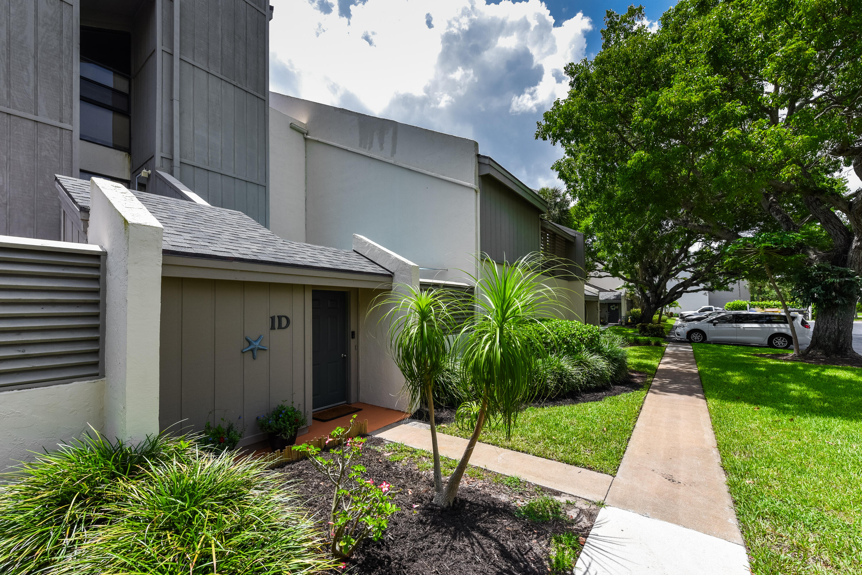 1605 Highway 1, Unit 1D Jupiter, FL 33477 - Photo 8 of 54 a backyard of a house with plants and large tree