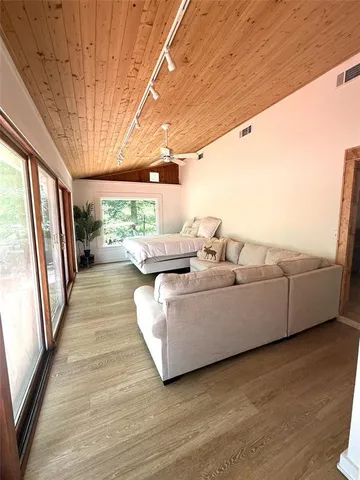 a spacious bedroom with a bed wooden floor and a large window