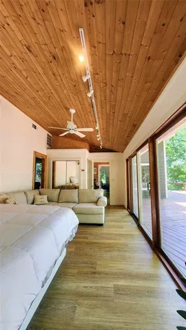 a bedroom with a large bed and a large window with balcony view