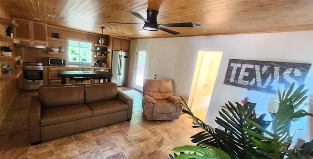 a living room with furniture a potted plant a fireplace and a window