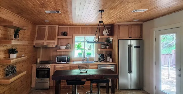 a kitchen with stainless steel appliances wooden cabinets and a stove top oven
