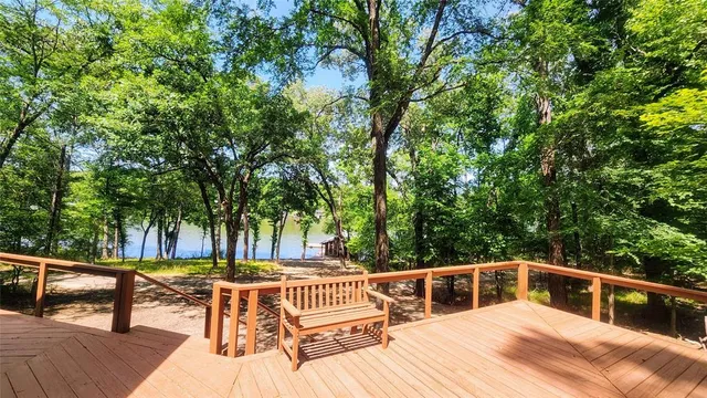a view of house with deck and a backyard