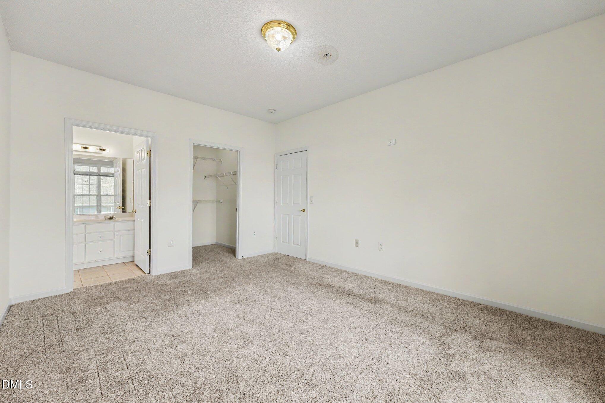 2521 Friedland Place Raleigh, NC 27617 - Photo 13 of 21 Primary suite retreat featuring a walk-in closet with built-in shelving and direct access to the private ensuite bathroom.