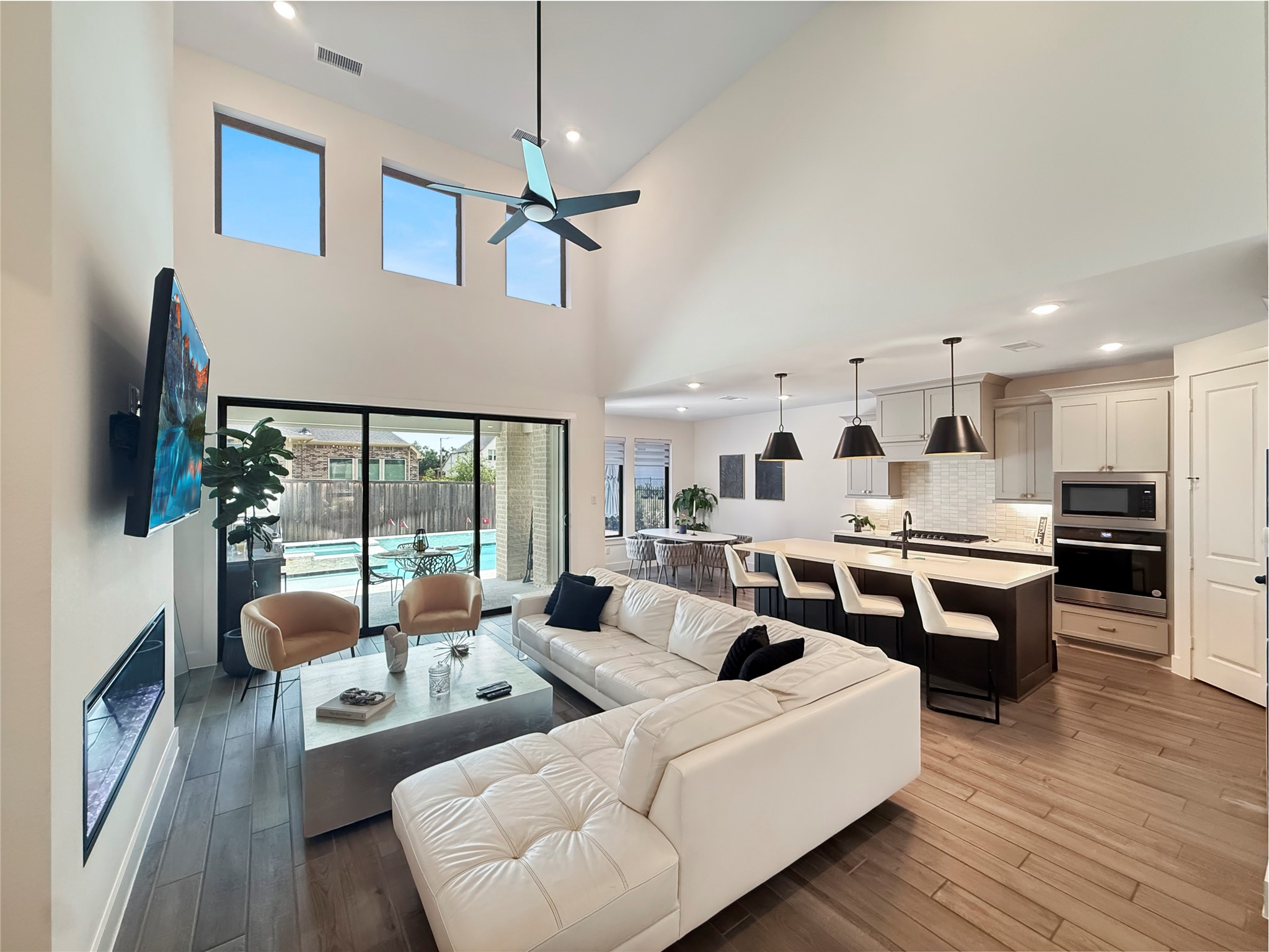 26918 Swanborough Road Spring, TX 77389 - Photo 49 of 50 This sun-drenched family room anchors the open floor plan, with sliding glass doors framing direct views of the sparkling pool — perfect for watching the kids swim while you cook or relax.