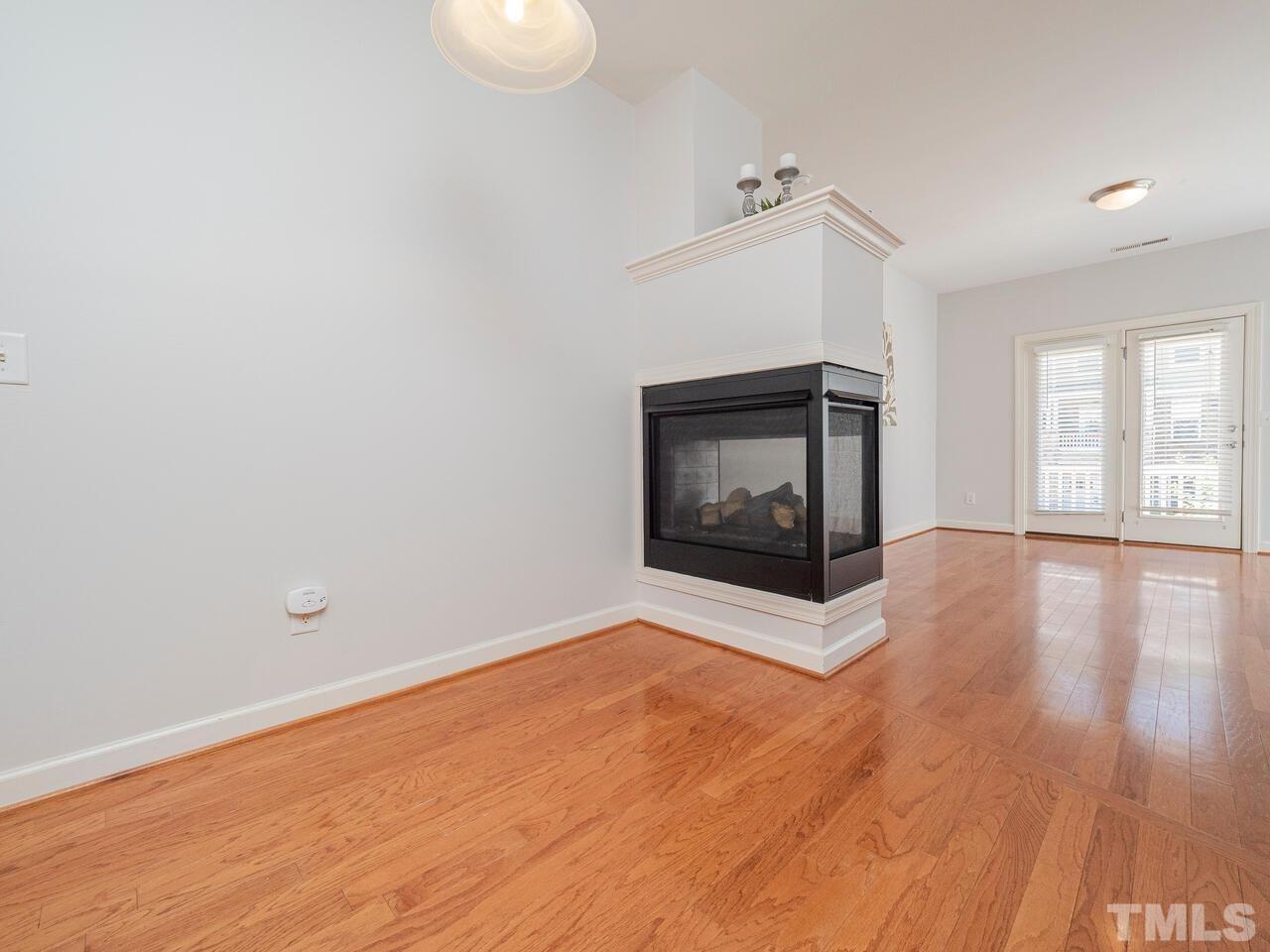 8007 Sycamore Hill Lane Raleigh, NC 27612 - Photo 8 of 22 Dual sided fireplace separates the family room from the dining area.