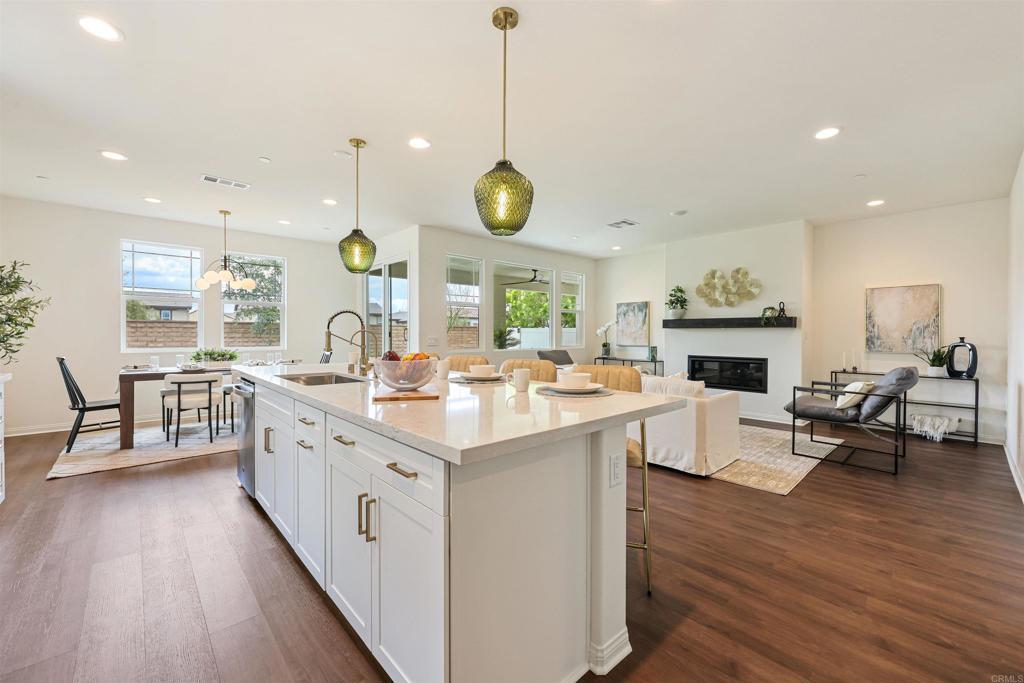 a kitchen with kitchen island granite countertop wooden floors and white cabinets