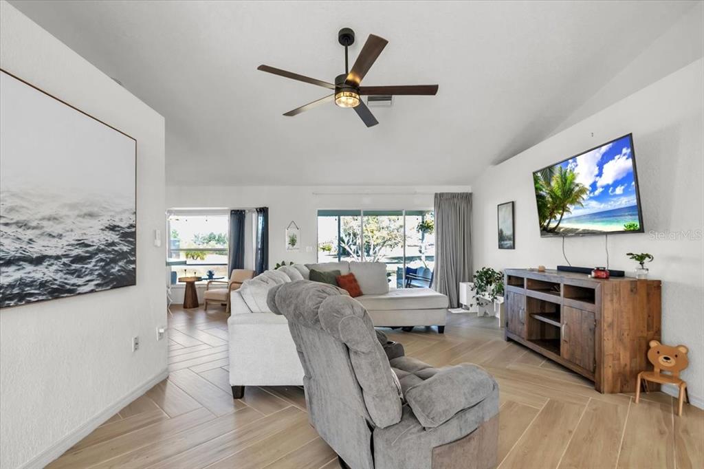 320 Tandil Street Punta Gorda, FL 33983 - Photo 12 of 67 a living room with furniture floor to ceiling window hardwood floor and a flat screen tv