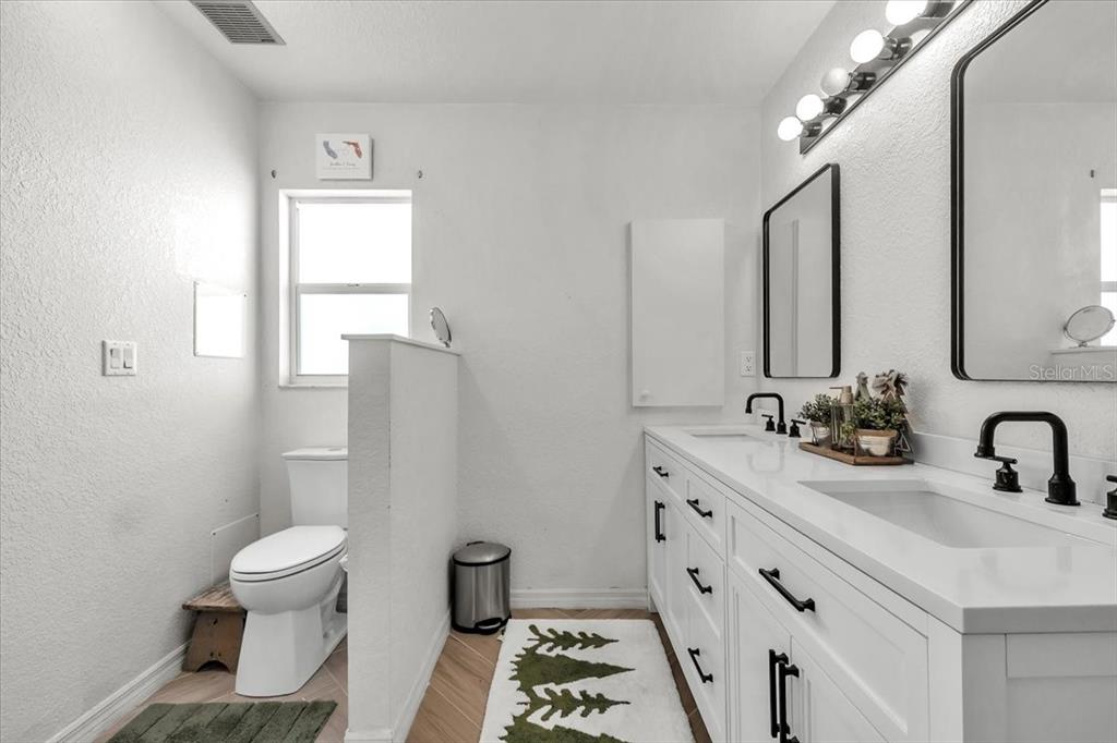 320 Tandil Street Punta Gorda, FL 33983 - Photo 36 of 67 a bathroom with a double vanity sink toilet and a mirror