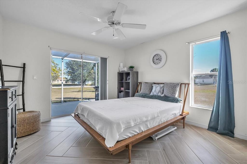 320 Tandil Street Punta Gorda, FL 33983 - Photo 43 of 67 a bedroom with a large bed and a chandelier