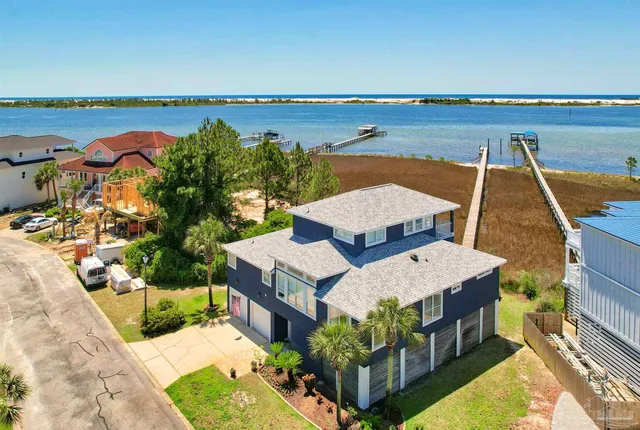 an aerial view of a house with a garden and lake view
