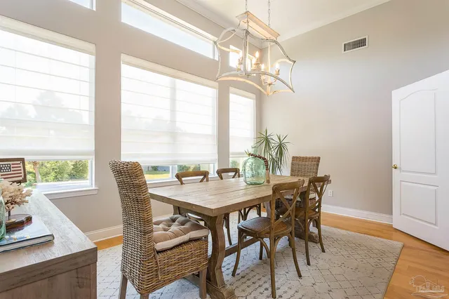 a view of a dining room with furniture a chandelier and wooden floor