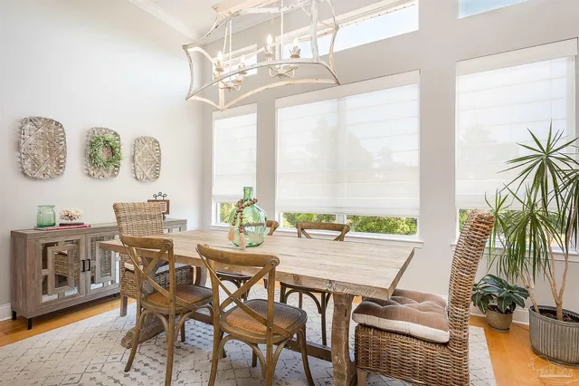 a view of a dining room with furniture a chandelier and wooden floor