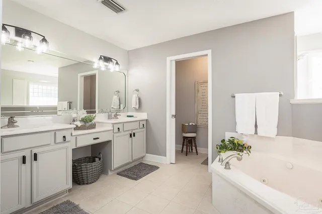 a spacious bathroom with a bathtub sink and mirror