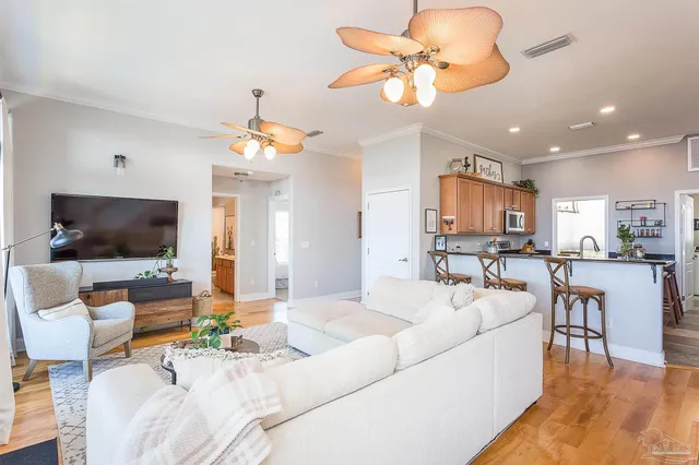 a living room with furniture a flat screen tv and kitchen view