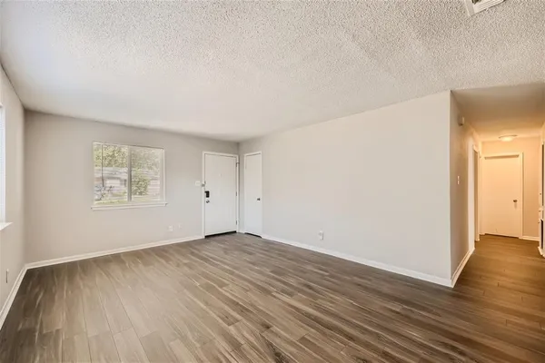 a view of an empty room with wooden floor