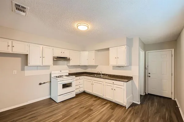 a kitchen with stainless steel appliances white cabinets and a hard wood floor
