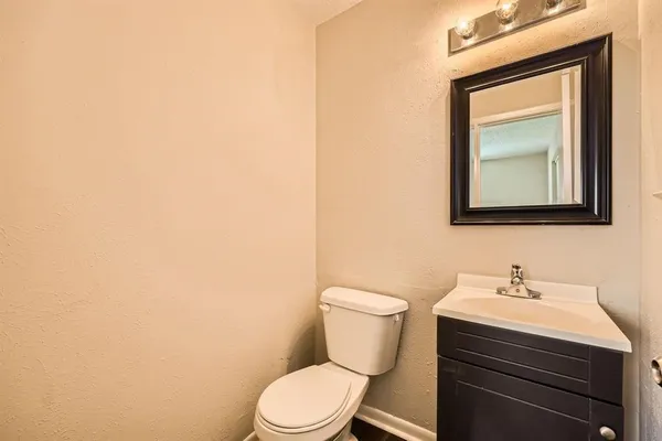 a bathroom with a toilet a sink and mirror