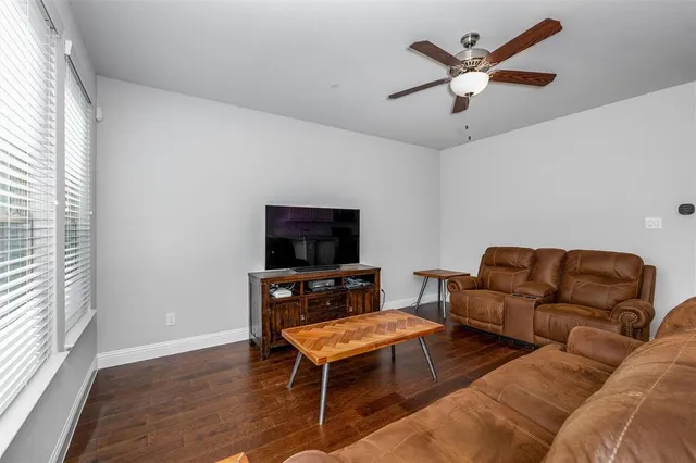 a living room with furniture a flat screen tv and a window