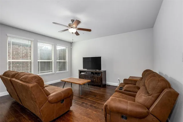 a living room with furniture ceiling fan and a window