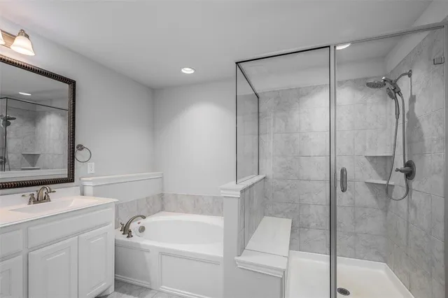 a bathroom with a tub sink shower and mirror