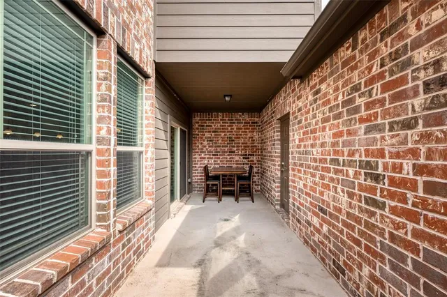 a view of a patio with table and chairs and a barbeque