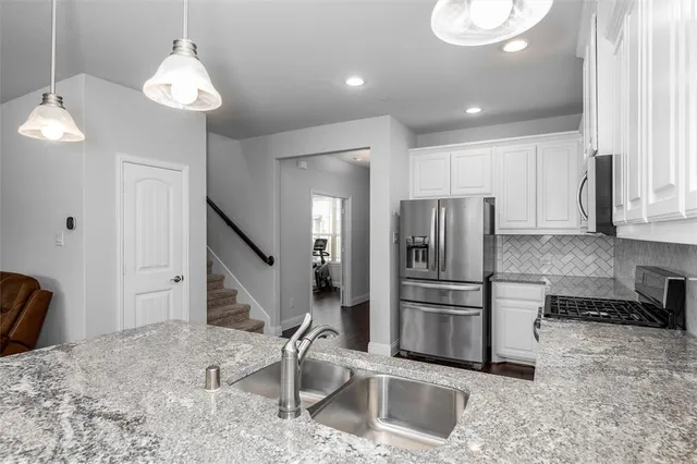 a kitchen with kitchen island a counter top space appliances and cabinets