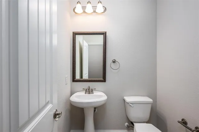 a bathroom with a toilet a sink and mirror