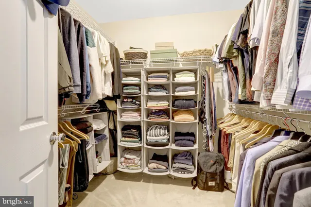 a view of walk in closet with clothes and shoes