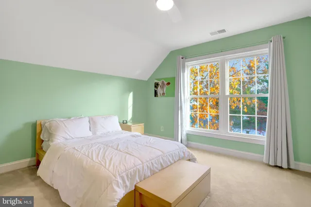 a spacious bedroom with a bed and a window