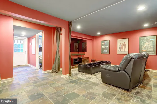 a living room with furniture a flat screen tv and large window