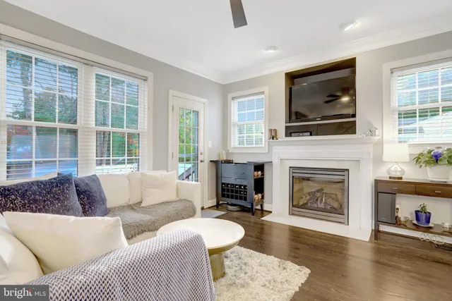 a living room with furniture a fireplace and a flat screen tv