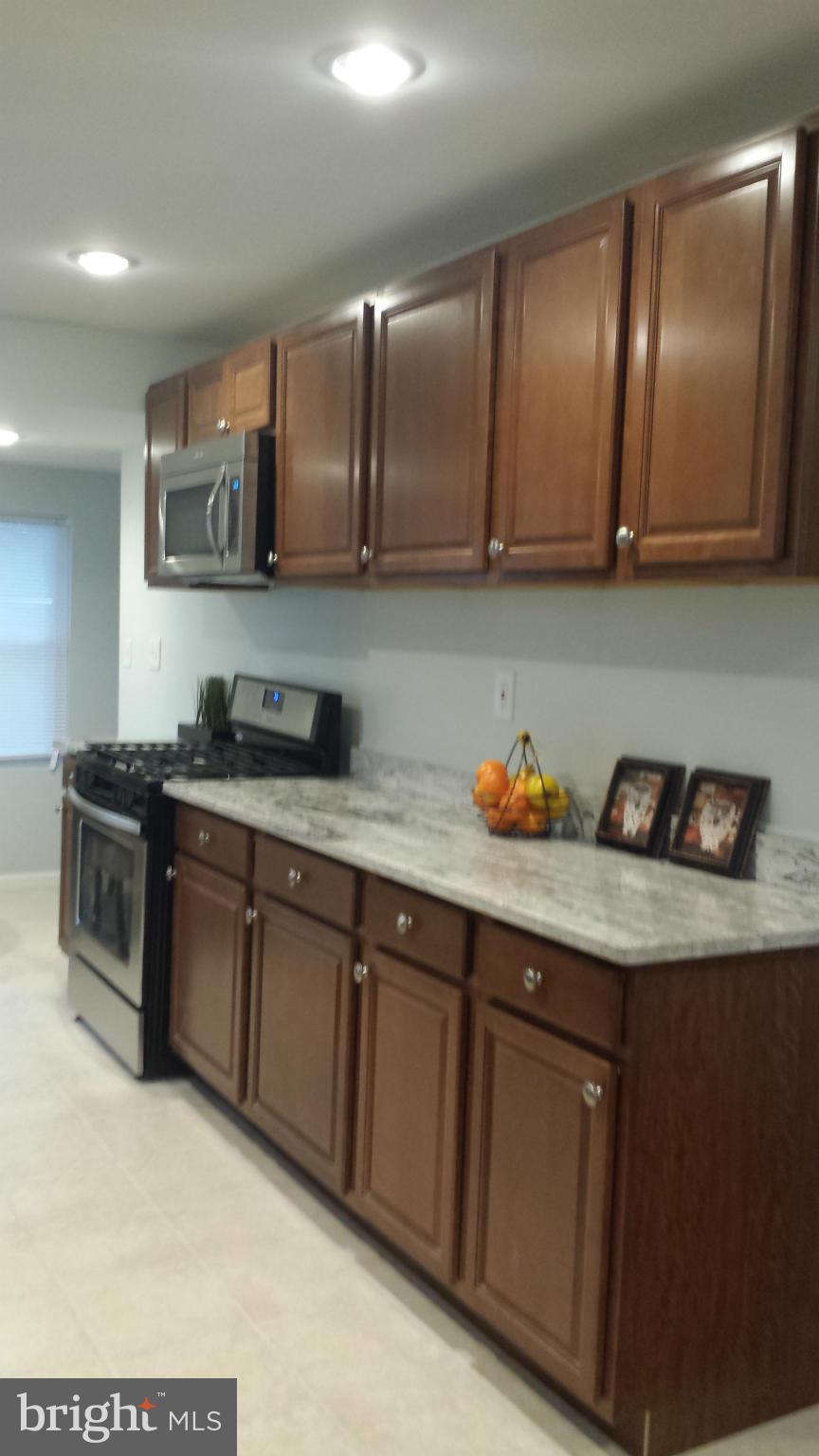 4511 Maple Road Morningside, MD 20746 - Photo 3 of 14 a kitchen with granite countertop stainless steel appliances wooden cabinets and a sink