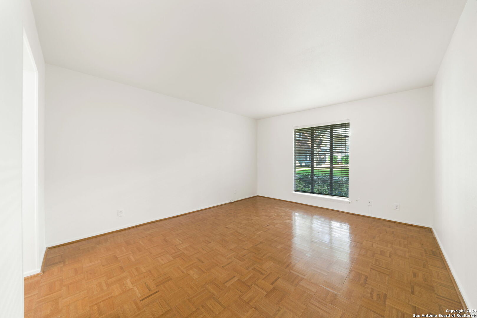 6106 Vance Jackson Road, Unit 50 San Antonio, TX 78230 - Photo 15 of 30 a view of an empty room with wooden floor and a window