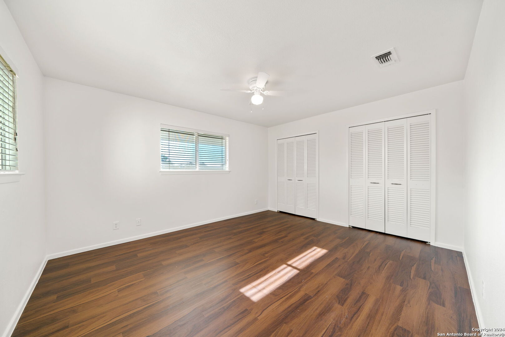 6106 Vance Jackson Road, Unit 50 San Antonio, TX 78230 - Photo 22 of 30 an empty room with wooden floor and windows