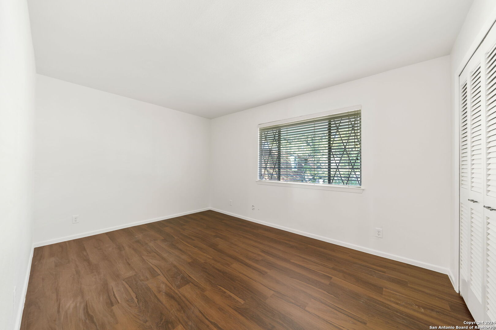 6106 Vance Jackson Road, Unit 50 San Antonio, TX 78230 - Photo 24 of 30 an empty room with wooden floor and windows