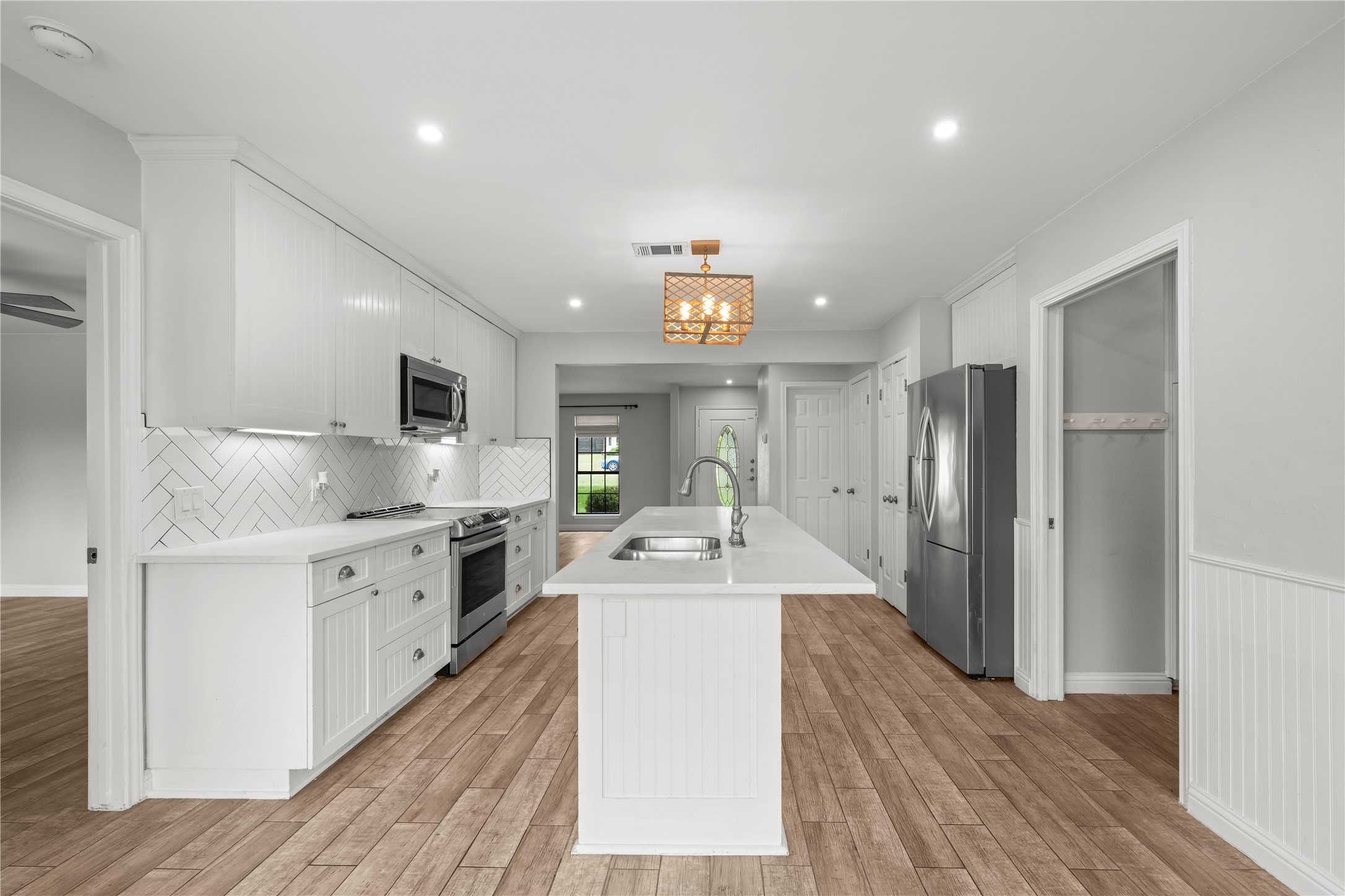 1329 Quail Ravine Round Rock, TX 78664 - Photo 37 of 39 Crisp white cabinetry paired with durable wood-look flooring defines this modern cooking space.