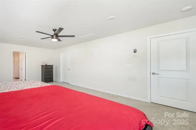 a bed room with a bed and a ceiling fan