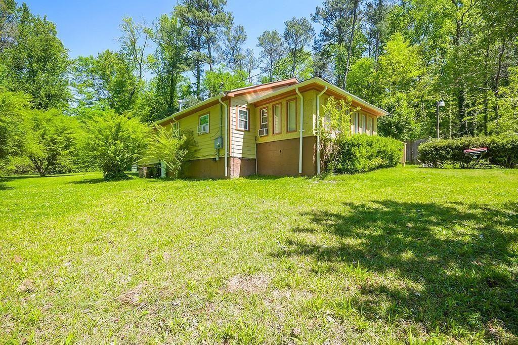 4231 Blanton Avenue Southwest Atlanta, GA 30331 - Photo 1 of 10 a yellow house sitting in middle of the green field
