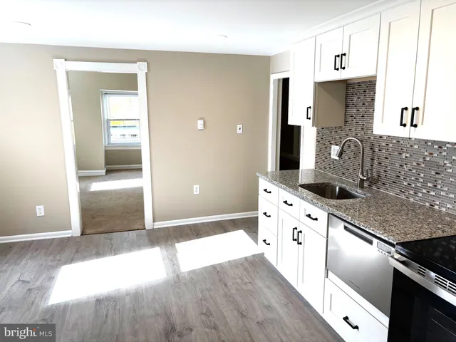 a kitchen with granite countertop a stove a sink and a refrigerator