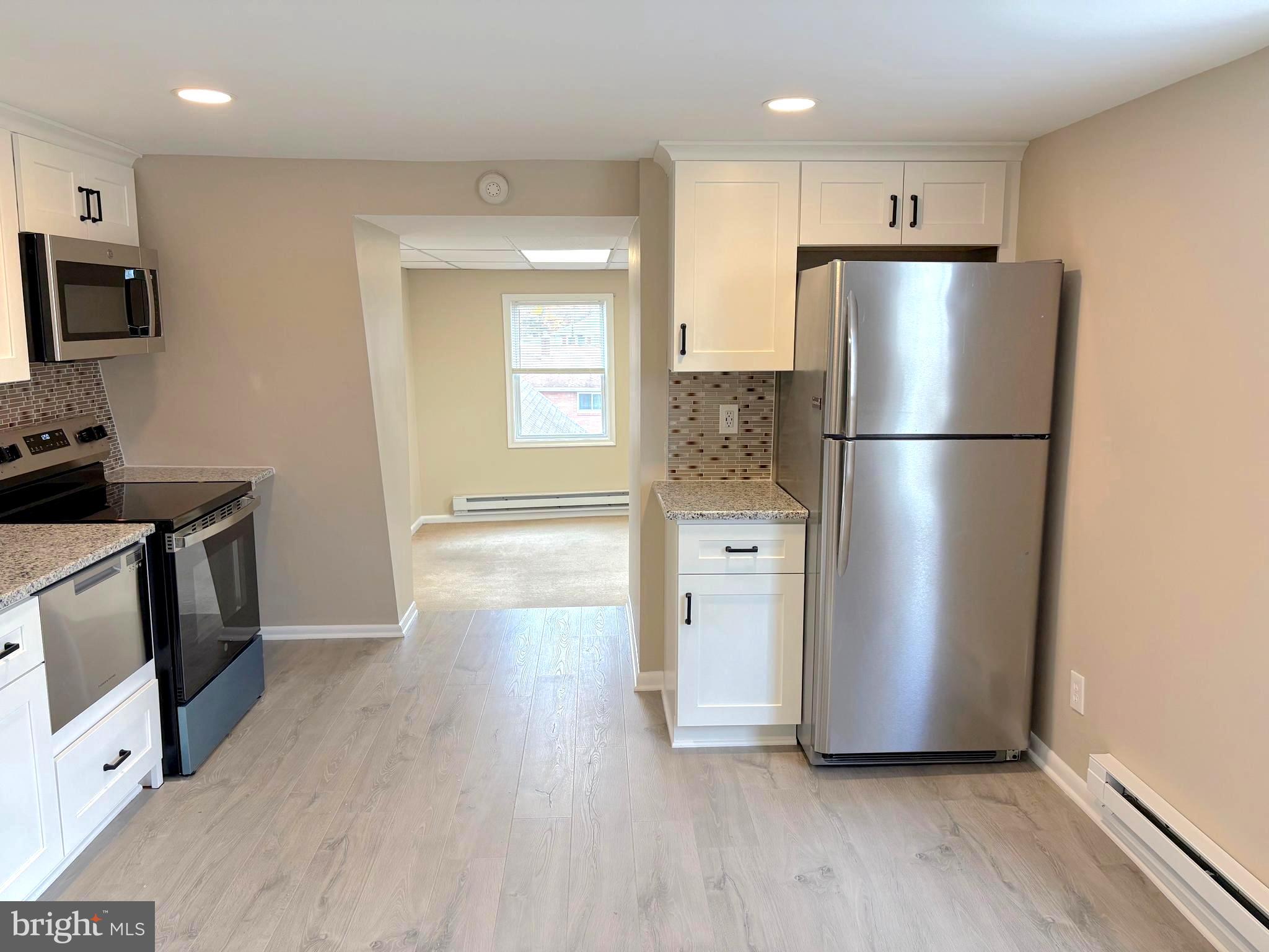 1643 Rockwell Road, Unit 5 Abington, PA 19001 - Photo 5 of 19 a kitchen with stainless steel appliances a refrigerator a sink a stove a microwave and cabinets