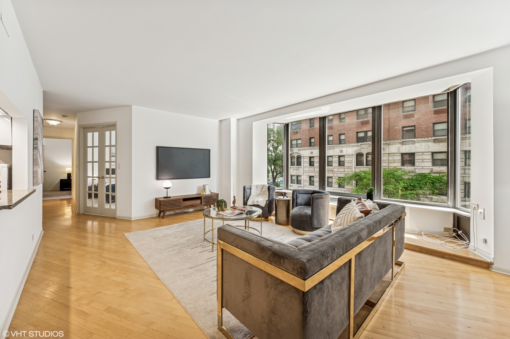 40 East Delaware Place, Unit 301 Chicago, IL 60611 - Photo 6 of 21 a living room with kitchen island furniture and a flat screen tv