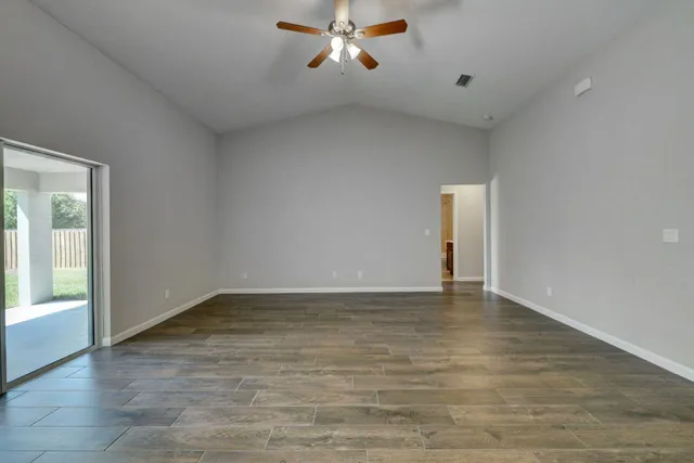 an empty room with closet and a ceiling fan