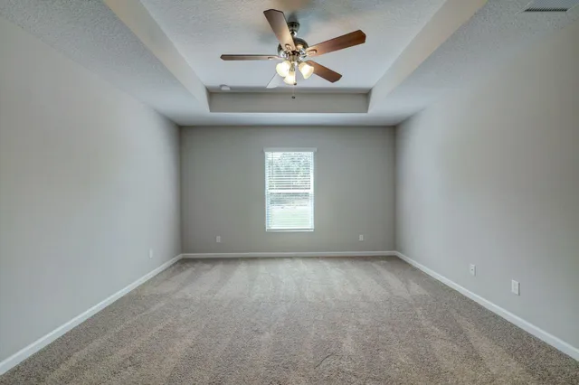 an empty room with a window and a fan