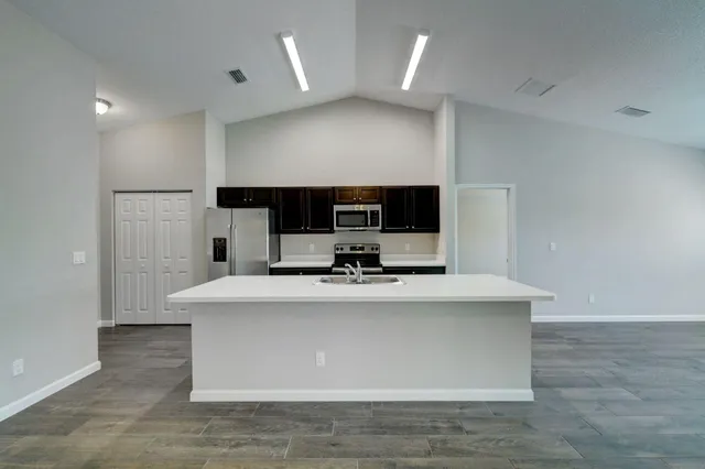 a view of kitchen with kitchen island a sink and a stove