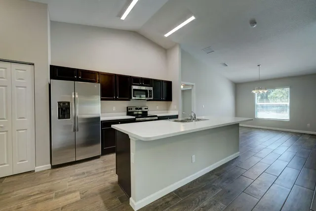 a kitchen with stainless steel appliances a refrigerator sink and microwave