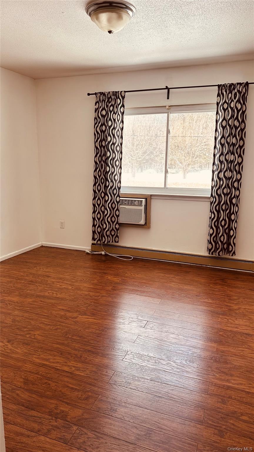 881 Albany Post Road, Unit 17 New Paltz, NY 12561 - Photo 12 of 15 an empty room with wooden floor and windows