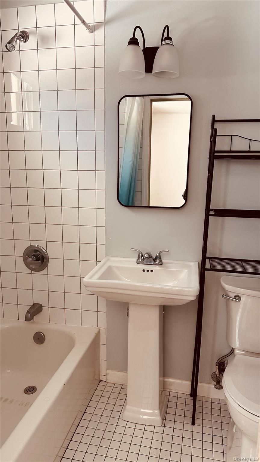 881 Albany Post Road, Unit 17 New Paltz, NY 12561 - Photo 13 of 15 a bathroom with a sink toilet and mirror