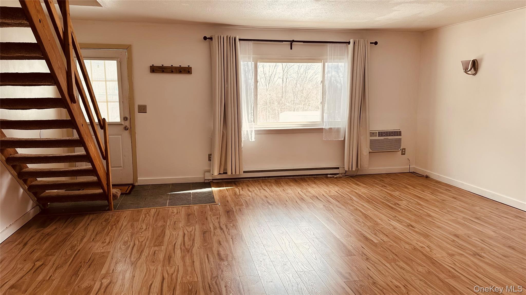 881 Albany Post Road, Unit 17 New Paltz, NY 12561 - Photo 4 of 15 an empty room with wooden floor and windows