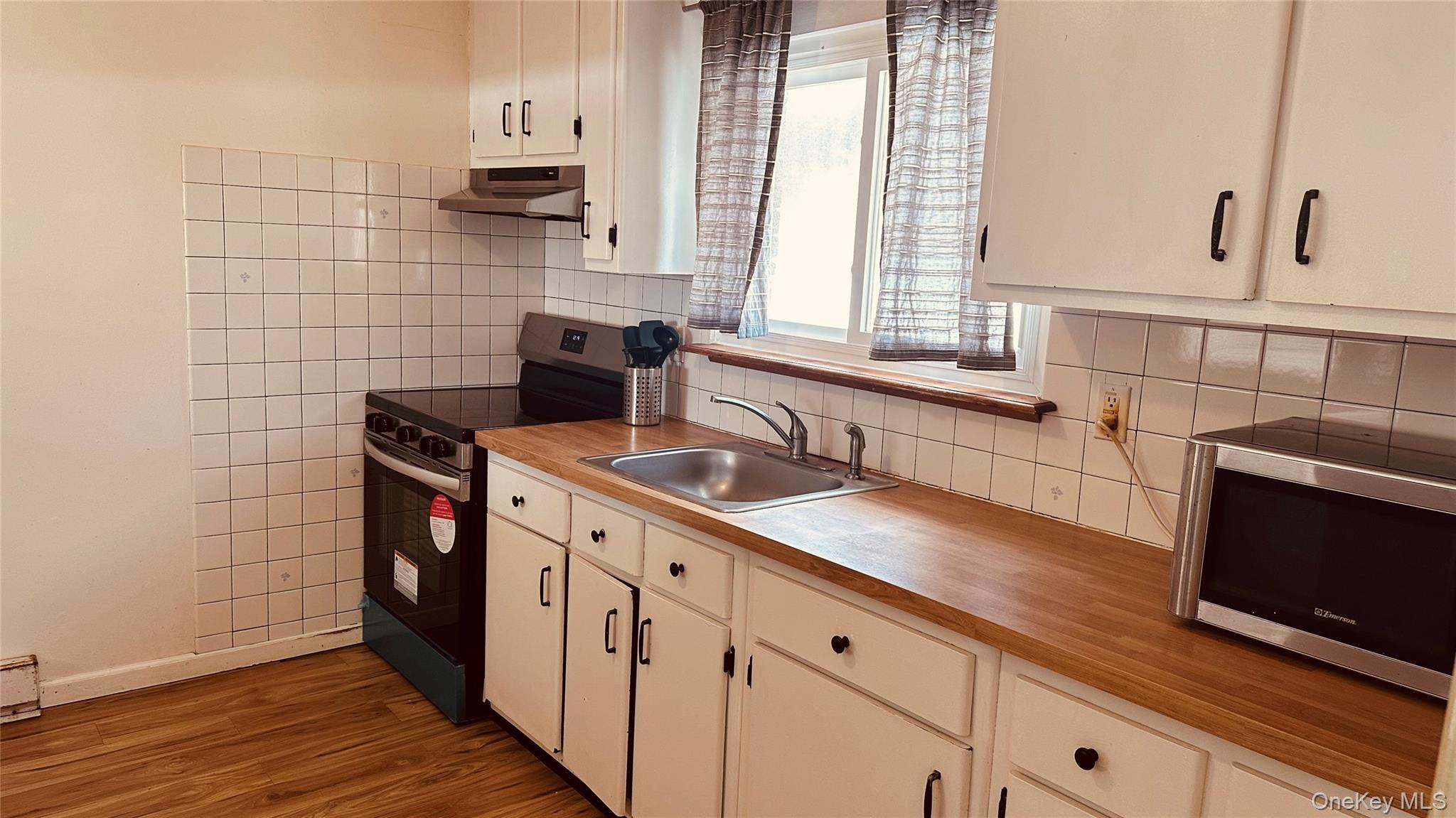 881 Albany Post Road, Unit 17 New Paltz, NY 12561 - Photo 5 of 15 a kitchen with stainless steel appliances a sink stove and cabinets